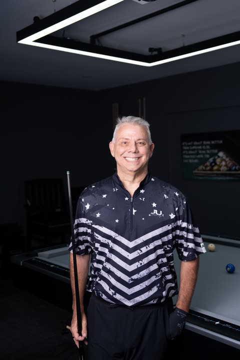 Mike Manuele standing at his home pool table